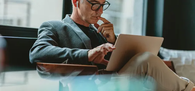 Businessman reading emails in office lobby